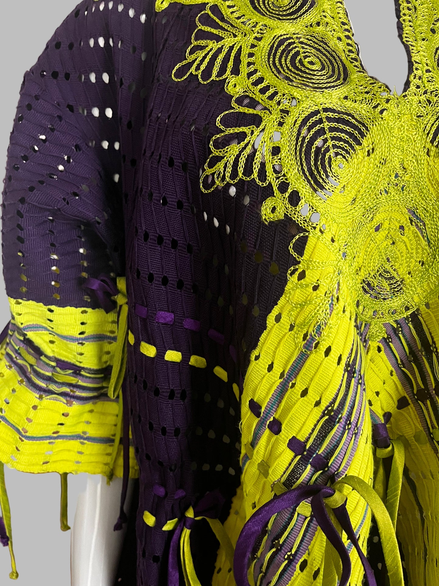 Close-up of a vibrant yellow and purple fabric with intricate patterns.